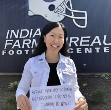 Beautiful woman holding up a sign that encourages why students should apply to college